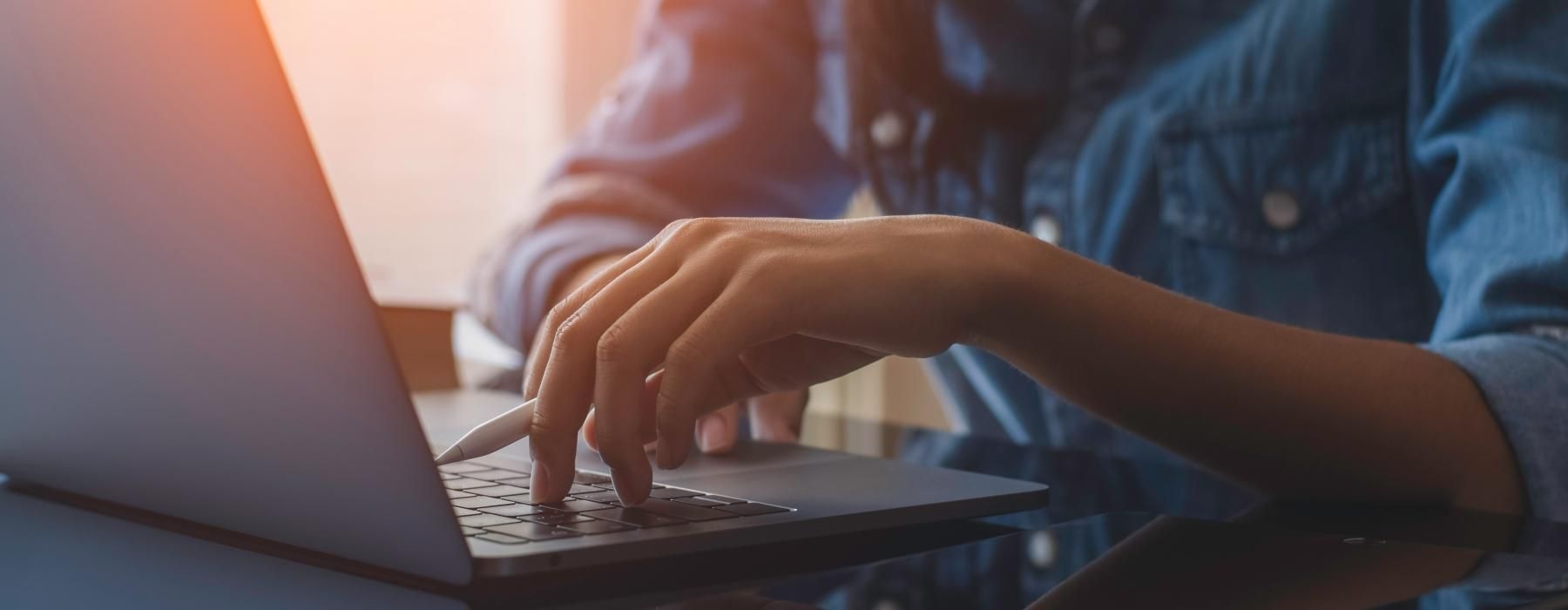 A person typing on a laptop scheduling a tour for our rental homes in Littleton, CO.