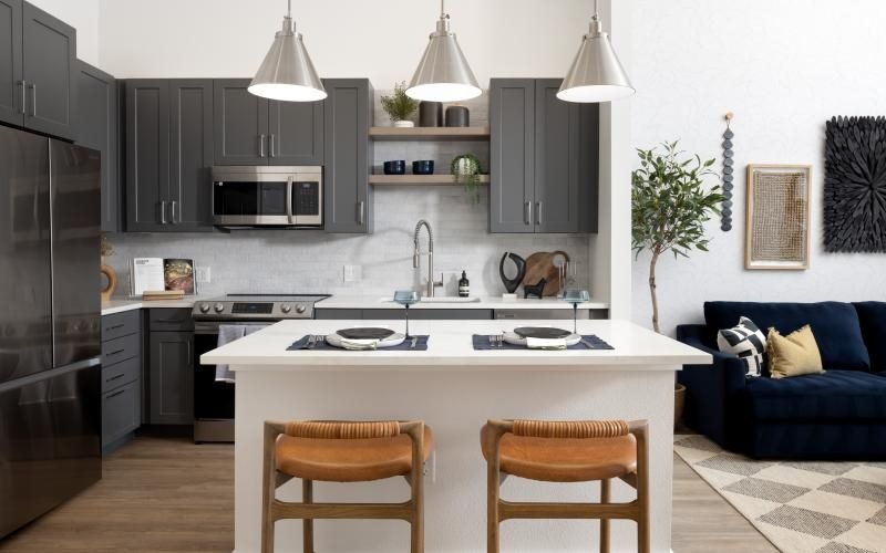 A kitchen with a table and chairs at an island in our Colorado apartments with a mountain view.